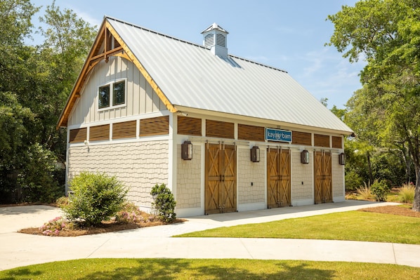 A building with a gabled roof, a chimney, and a sign reading "kayak barn".