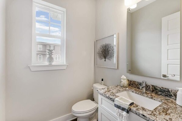 Un baño con inodoro, lavabo y ventana.