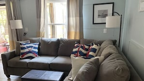 En opholdsstue med en modulsofa, et sofabord og en lampe.