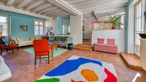 A spacious living room with a high ceiling, a large window, and a cozy seating area with a sofa and chairs. - Maison Prado - avec piscine privée et grand jardin (Magny-en-Vexin)