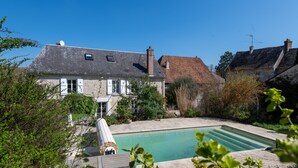 A house with a swimming pool, surrounded by greenery and a wooden deck. - Maison Prado - avec piscine privée et grand jardin (Magny-en-Vexin)