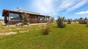A modern house with large glass windows, a wooden exterior, and a well-maintained lawn. - 3326 Villetta Jannara by Barbarhouse (Melendugno)