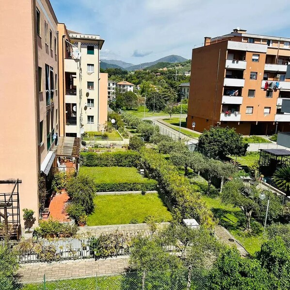 A residential area with multi-story buildings, a well-maintained garden, and a clear view of the surrounding landscape.