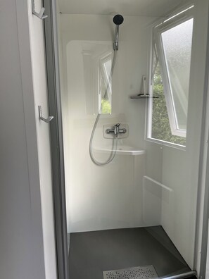 Regadera, secadora de cabello, papel de baño 