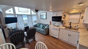 A compact living space with a kitchenette, a dining area, and a sofa. - Oceanfront Cabin 4 with Private Jacuzzi & Stunning Views (Smith River)