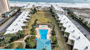 Resort com piscina central, vários edifícios e vista para a praia.