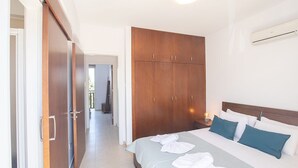 A hotel room with a bed, a wardrobe, and an air conditioning unit. - Villa Meena, 2BDR Kapparis Villa with Private Pool, Close to the Beach (Paralimni)