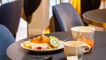 Et morgenbord med croissant, kiwi og appelsinjuice.