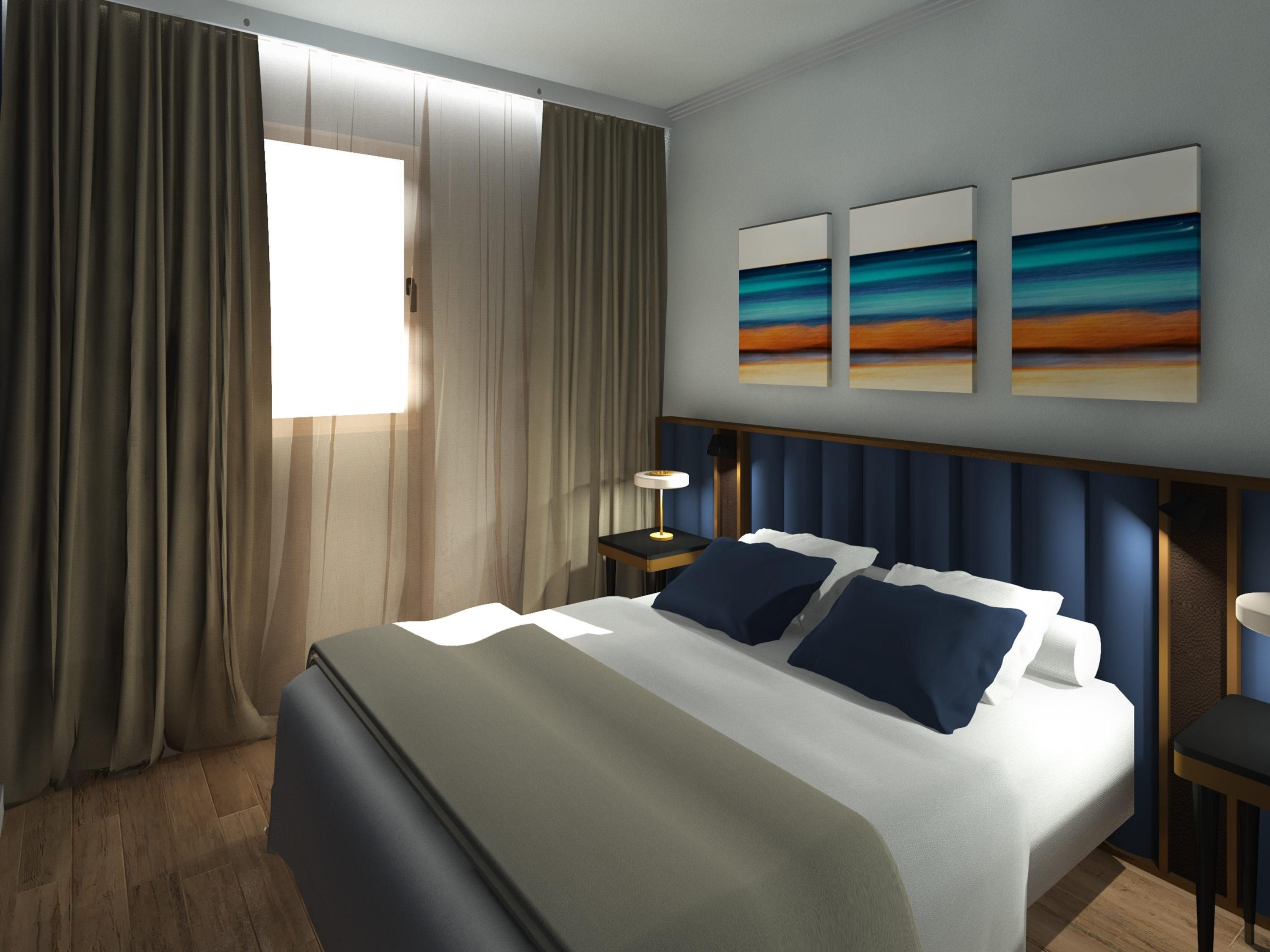 Habitación de hotel moderna con una cama grande, una mesita de noche, una lámpara y tres cuadros colgados en la pared.
