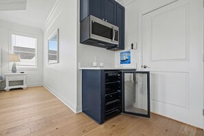 A compact kitchen with a microwave, a built-in oven, and a refrigerator.