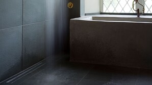 Ein Badezimmer mit Dusche, Waschbecken und einem Fenster mit Aussicht.