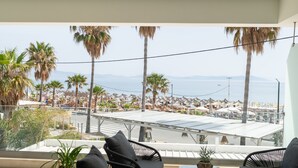 A balcony with a view of a beach, palm trees, and a cityscape. - beach deluxe house  (Kos)
