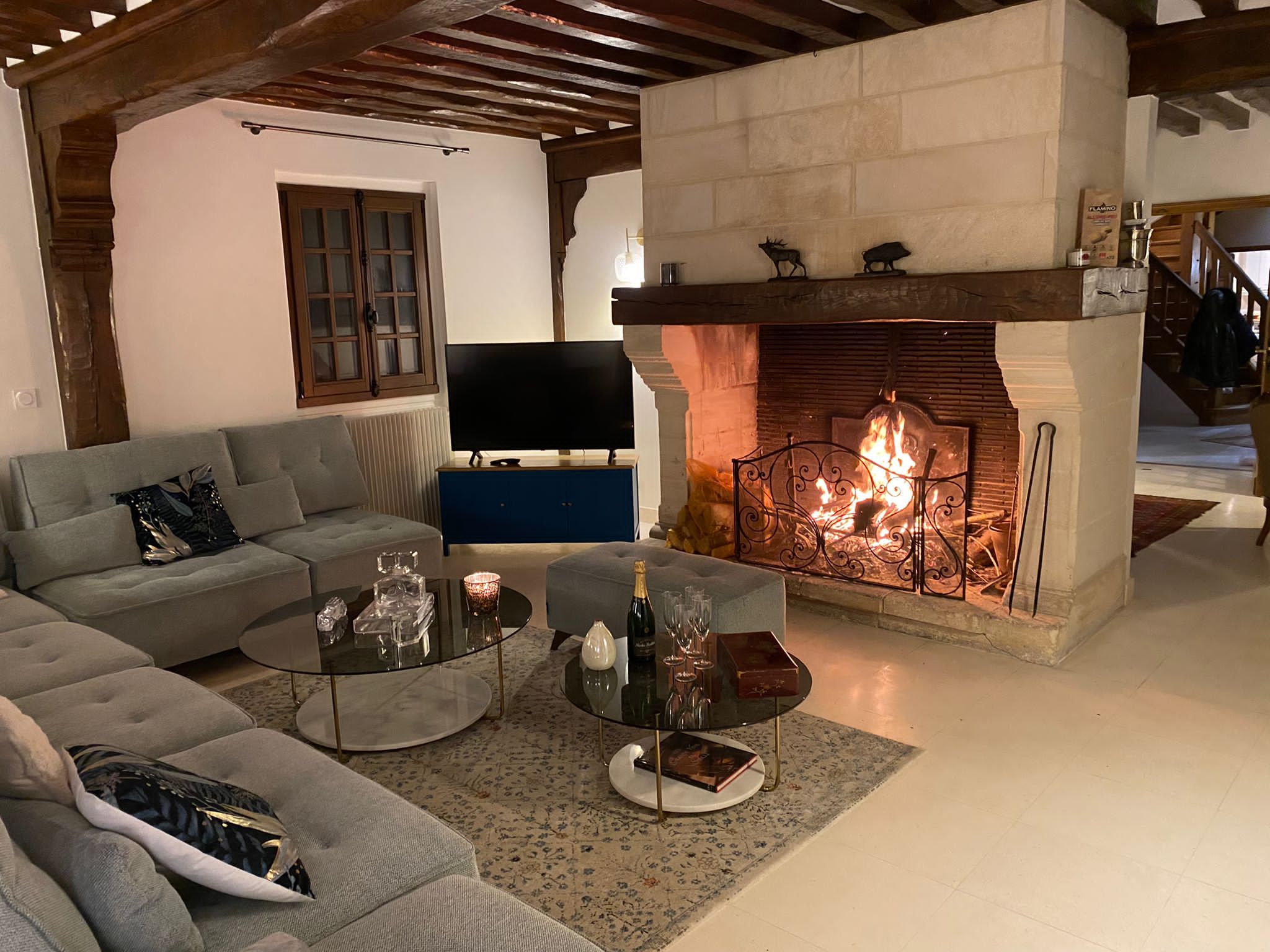 A living room with a fireplace, a sofa, a coffee table, and a television.