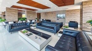 A modern living room with black sofas, a coffee table, and wooden ceiling panels. - Spectacular + cozy brand new apartment! (Santa Cruz de la Sierra)