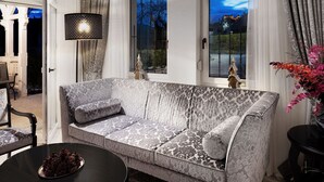Ein modernes Wohnzimmer mit einer gemusterten Couch, einem runden Couchtisch und einer dekorativen Lampe.
