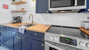 Une cuisine équipée d’un four à micro-ondes, d’une cuisinière et d’une machine à café.
