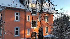 A large, multi-story building with a symmetrical facade, multiple windows, and a central entrance.