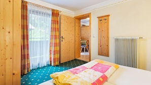 Una habitación de hotel con cama, armario de madera y radiador.