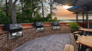 Enjoy al fresco dining and cooking on the patio, featuring barbecue grills and a dining area with a covered seating space.