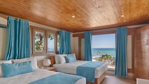 Ein Zimmer mit zwei Betten, Holzbalkendecke und Meerblick.