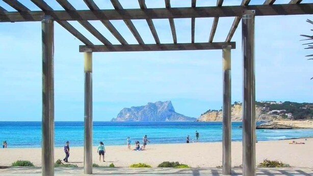 A covered outdoor area with a view of the beach and a mountain in the background. - Villa El Barranco (Teulada)
