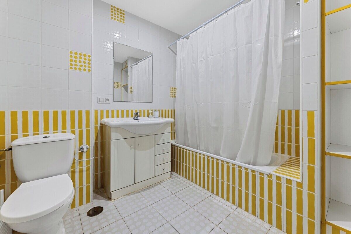 Une salle de bain comprenant des toilettes, un lavabo et un espace douche.