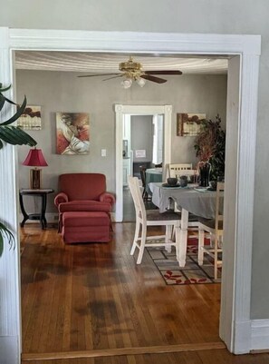 Enjoy meals in this inviting dining area with a dining table for four, a comfortable armchair, and beautiful artwork on the walls.