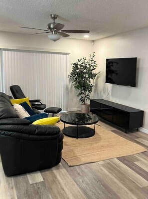 Relax in this stylish living room with a comfortable sofa, flat-screen TV, and potted plant.