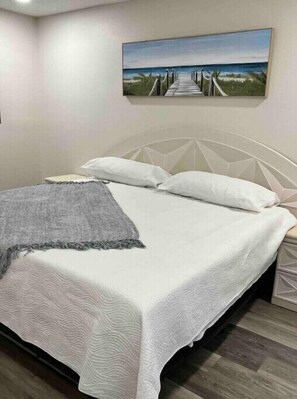 Cozy retreat with a single bed, white headboard, and textured bedspread.