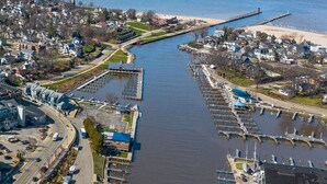 Vue aérienne d’une ville côtière avec un port de plaisance, un pont et une plage.