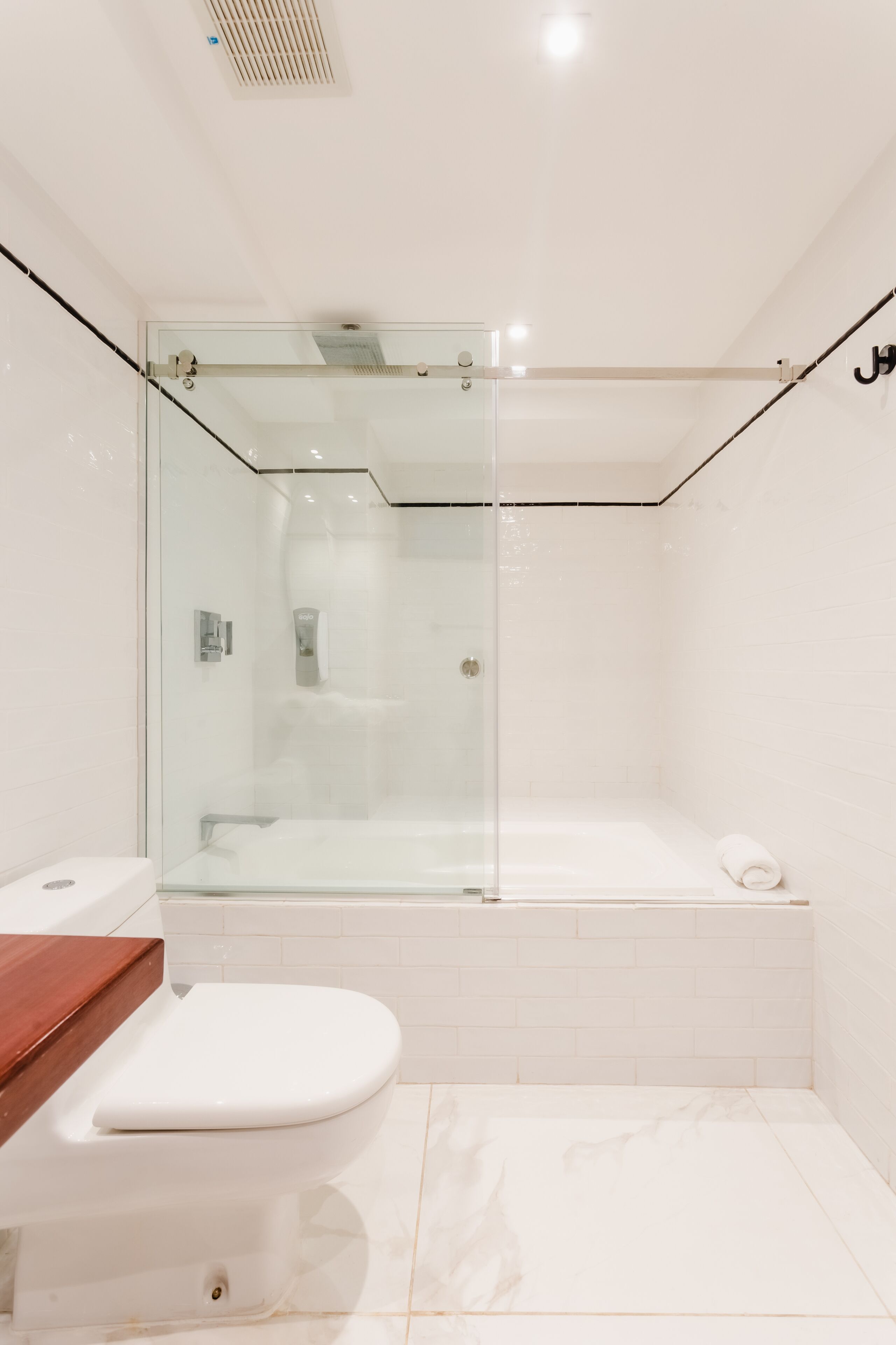 Un baño moderno con ducha de vidrio, inodoro blanco y bañera.