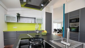 Una cocina moderna con una isla central, electrodomésticos de acero inoxidable y un salpicadero de color verde brillante.