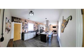 Enjoy cooking in this well-equipped kitchen with a central island, refrigerator, and microwave.