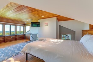 A modern bedroom with a large bed, wooden ceiling, and a view through the window. - Wellness Retreat w/ Views! Upscale Marlboro Cabin (Marlboro)
