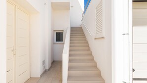Ein schmaler Flur mit einer Treppe zu einer Tür.
