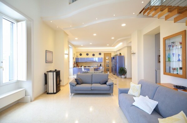 A modern living room with a sofa, a coffee table, and a fireplace. - Panorama Suite (Vico Equense)