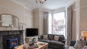 A living room with a fireplace, a sofa, a coffee table, and a television.