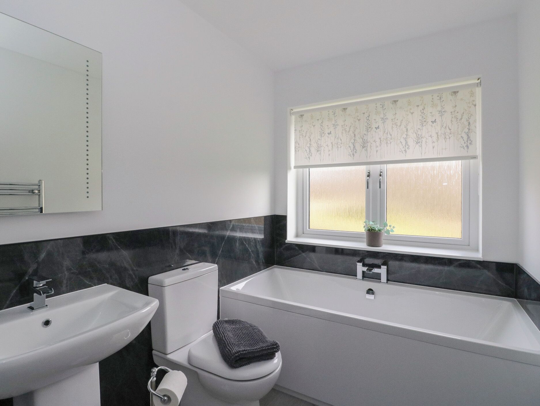 A bathroom with a toilet, sink, and bathtub.