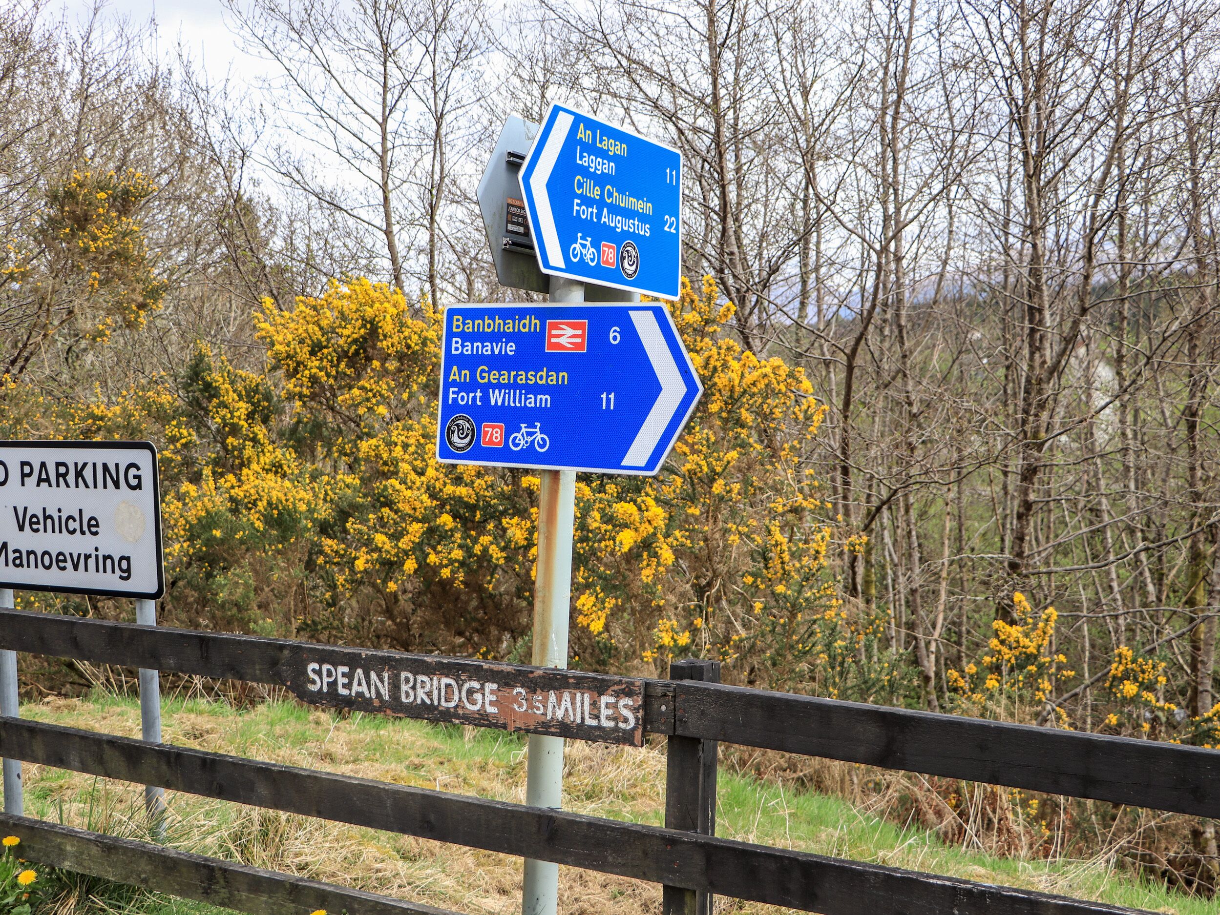 Een richtingsbord met verschillende routeaanduidingen en een parkeerverbod.
