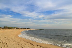 Pantai di sekitar, kursi berjemur, payung pantai, dan handuk pantai