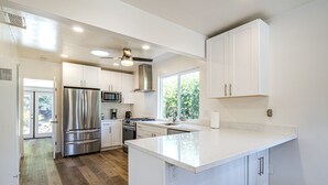 A modern kitchen with white cabinetry, stainless steel appliances, and a large island. - Fantastic, modern 2bdr Cottage, 5min to beach (Santa Cruz)