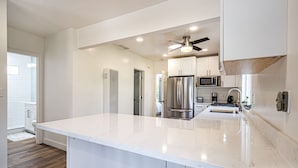 A modern kitchen with a large island, stainless steel appliances, and white cabinetry. - Fantastic, modern 2bdr Cottage, 5min to beach (Santa Cruz)