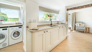 Una cocina moderna con electrodomésticos integrados, un amplio ventanal con vistas y una zona de estar acogedora.