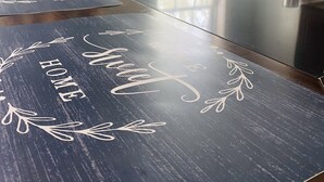 Una cocina con encimera de madera oscura, microondas blanco y ventana con luz natural.