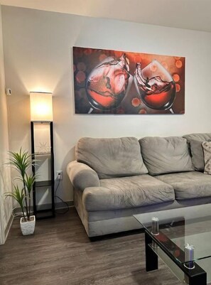 Relax in this stylish living room with a sofa, floor lamp, and potted plant.