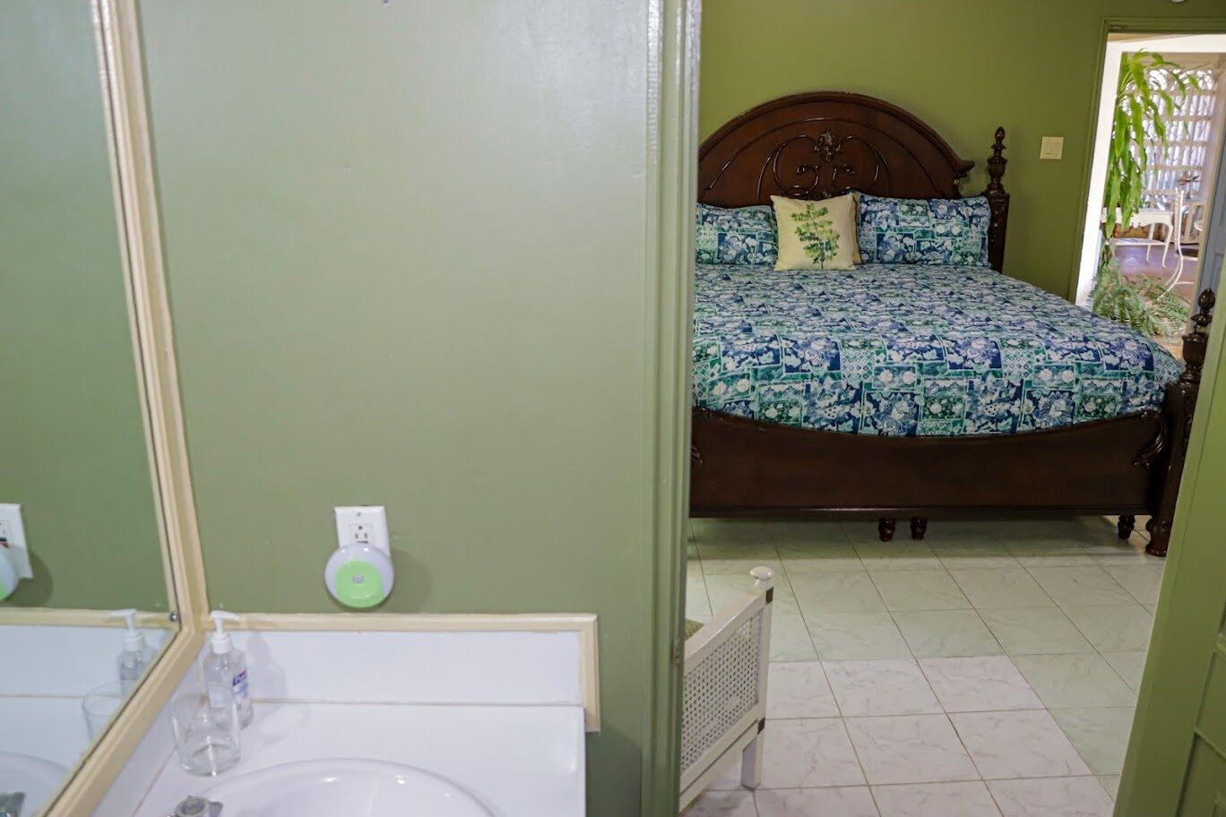 A bedroom with a bed, a nightstand, and a mirror.