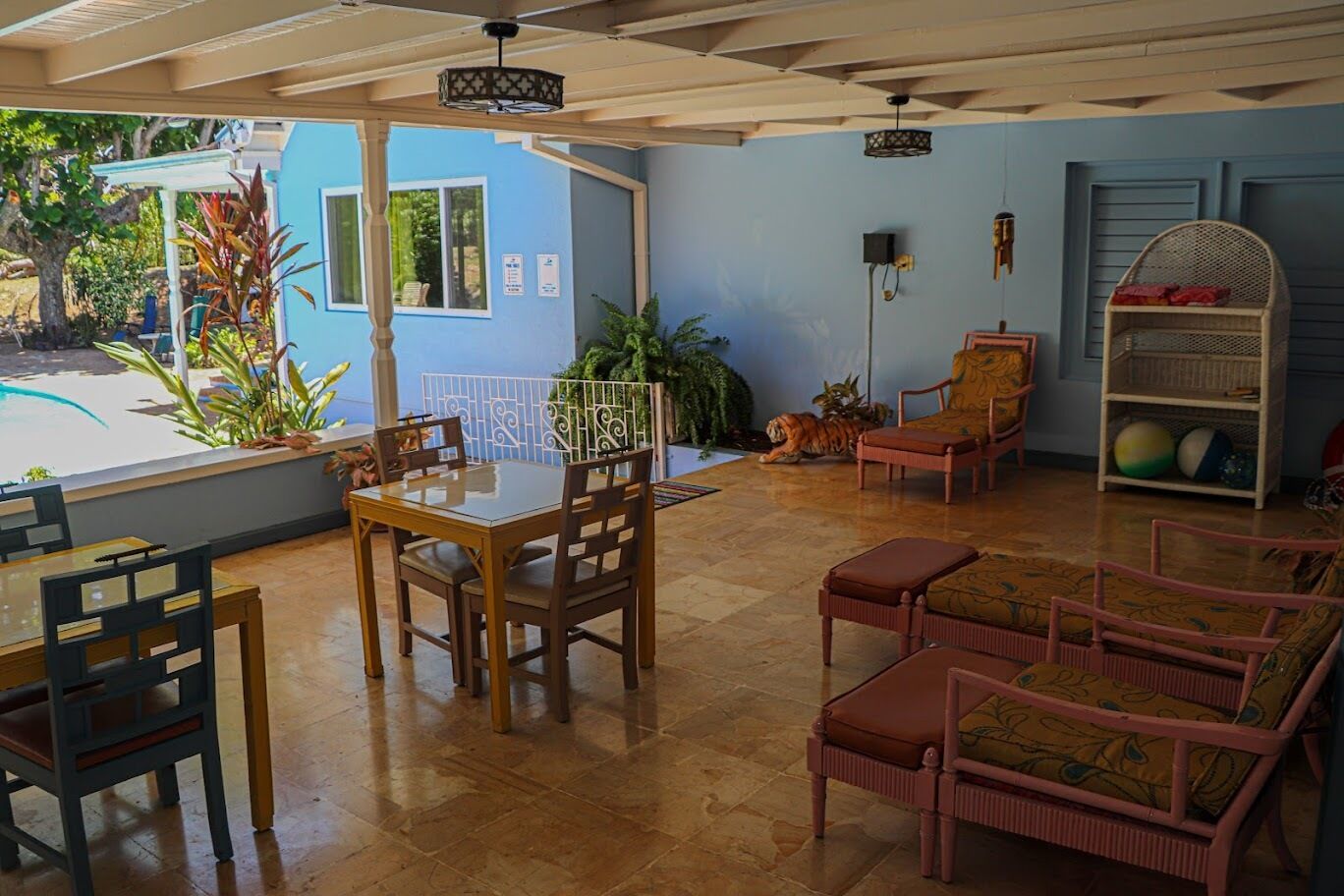 A spacious indoor area with a dining table and chairs, a sofa, and a decorative tiger statue.