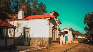 A traditional building with a red-tiled roof, a small tower, and a door with a blue frame.