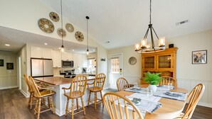 A spacious kitchen with a central island, wooden chairs, and a dining table set for six. - Charming Condo on Sky Valley Golf Course! (Sky Valley)