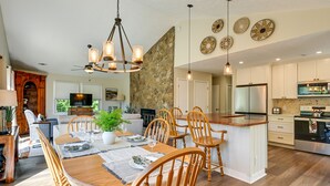 A spacious kitchen with a central island, wooden chairs, and a dining table set for six. - Charming Condo on Sky Valley Golf Course! (Sky Valley)
